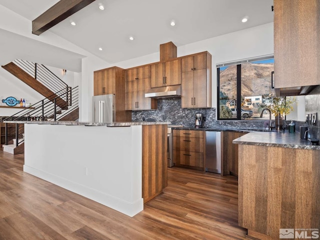 kitchen with stainless steel appliances, a kitchen island, sink, and dark hardwood / wood-style flooring