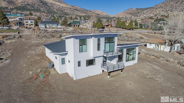 exterior space with a mountain view, a balcony, and central air condition unit