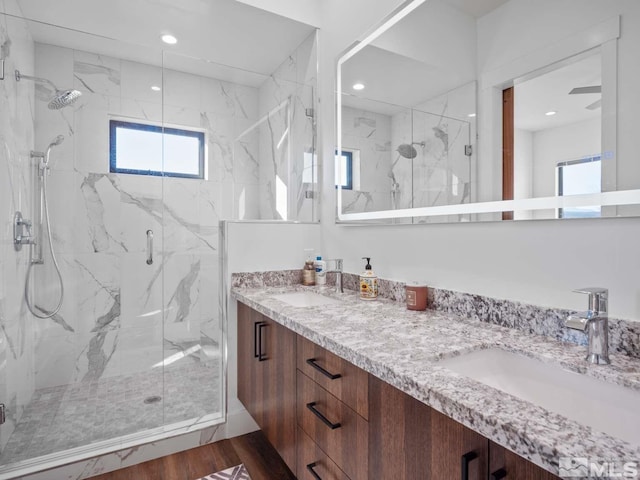 bathroom featuring vanity, hardwood / wood-style flooring, and a shower with door