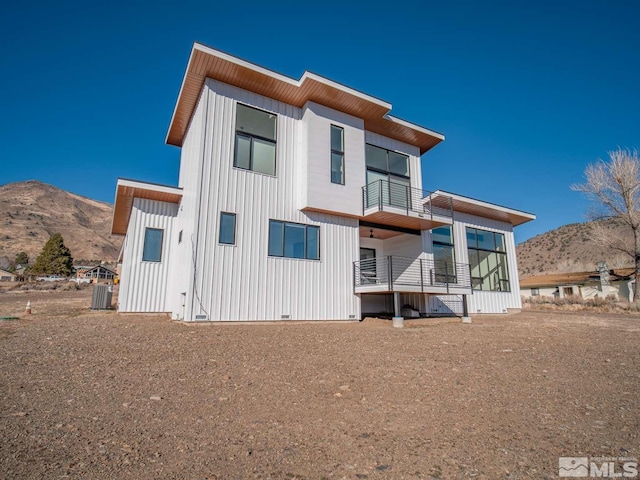 rear view of house featuring cooling unit and a mountain view