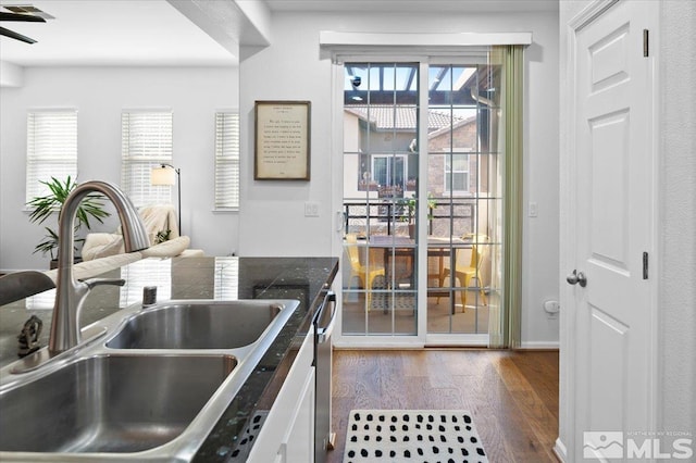 kitchen with sink, stainless steel dishwasher, white cabinets, and dark hardwood / wood-style floors