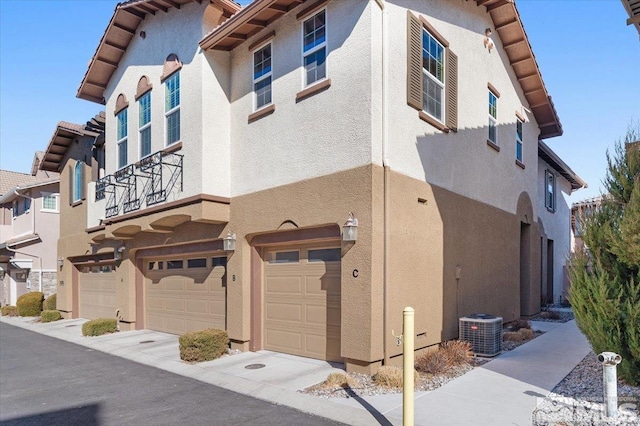 exterior space with central AC unit and a garage