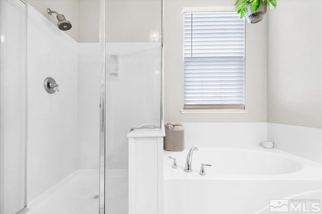 bathroom featuring independent shower and bath