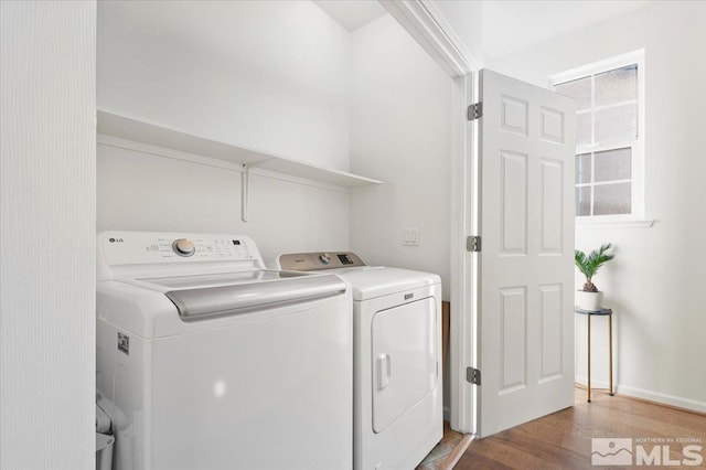 clothes washing area featuring wood-type flooring and washer and dryer