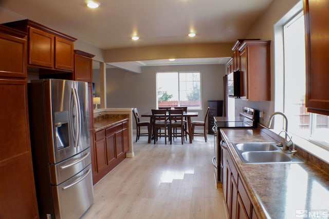 kitchen featuring appliances with stainless steel finishes, sink, and light wood-type flooring