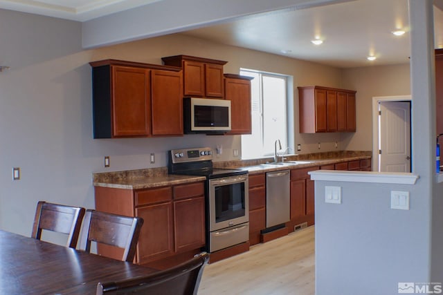 kitchen featuring stainless steel appliances, light hardwood / wood-style floors, and sink