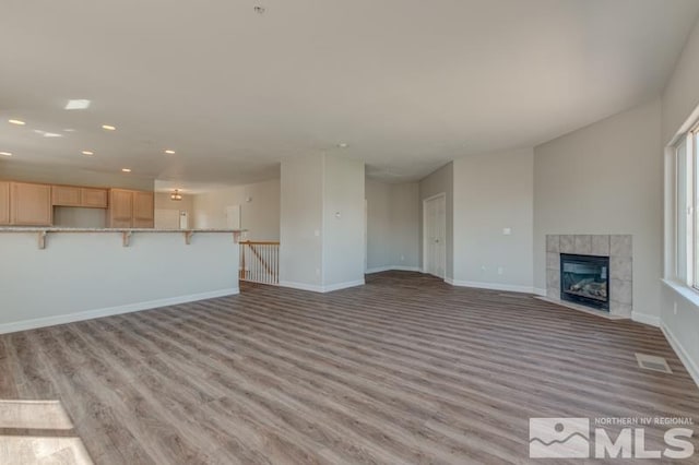 unfurnished living room featuring light wood-type flooring and a fireplace