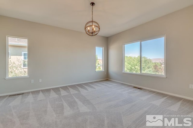 unfurnished room with light carpet and a chandelier