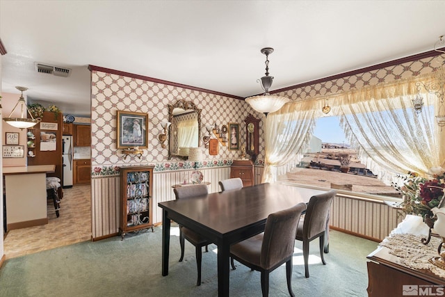 carpeted dining space with ornamental molding and radiator