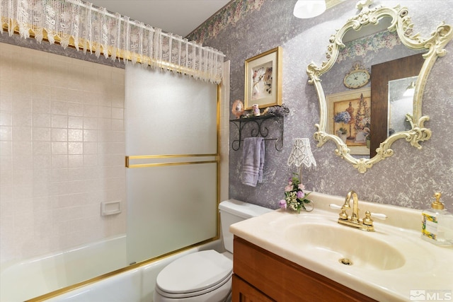 full bathroom with bath / shower combo with glass door, vanity, and toilet