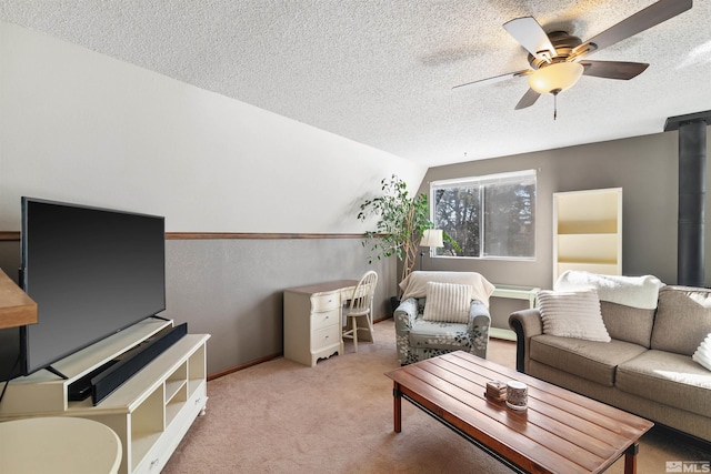 living room featuring light carpet, ceiling fan, and a textured ceiling