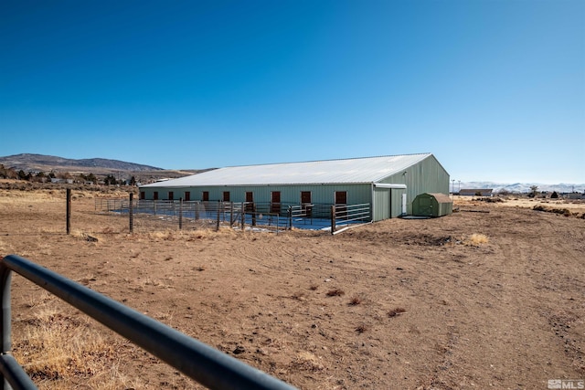 view of horse barn with a mountain view and a rural view