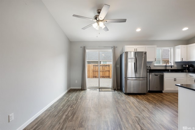 kitchen featuring sink, ceiling fan, appliances with stainless steel finishes, white cabinetry, and wood-type flooring