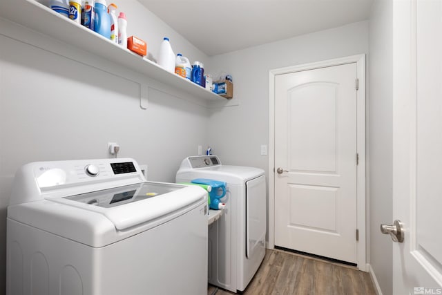 washroom with dark wood-type flooring and separate washer and dryer