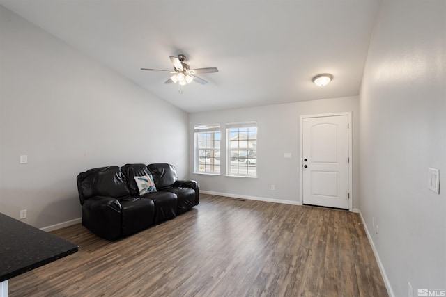 living room with dark wood-type flooring, ceiling fan, and vaulted ceiling