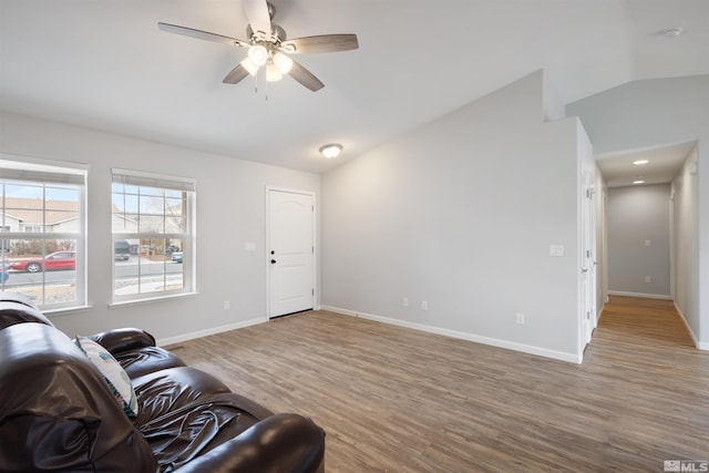 living room featuring lofted ceiling, wood-type flooring, and ceiling fan