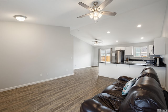 living room with vaulted ceiling, dark hardwood / wood-style floors, sink, and ceiling fan