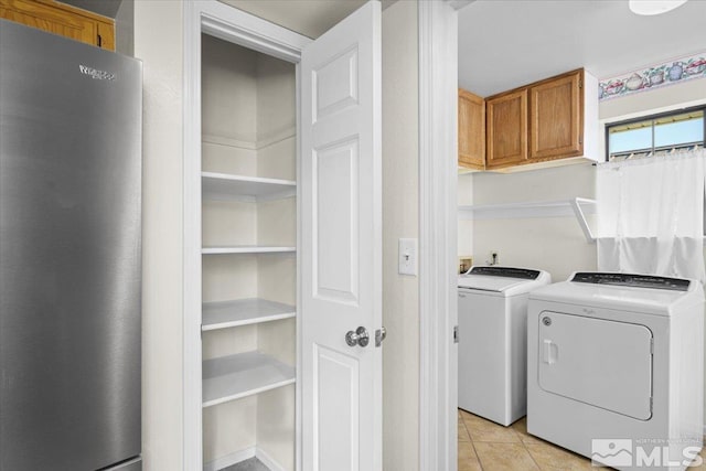 laundry room featuring independent washer and dryer and light tile patterned floors