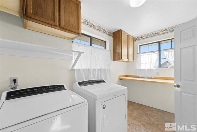 laundry area featuring cabinets and washing machine and clothes dryer