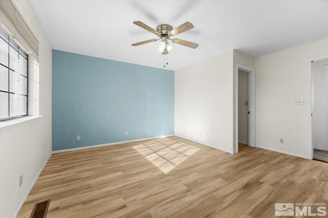 empty room with ceiling fan and light hardwood / wood-style flooring