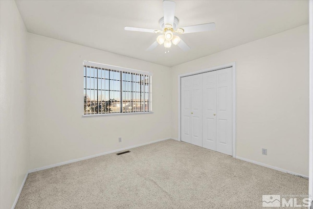 unfurnished bedroom with a closet, ceiling fan, and carpet