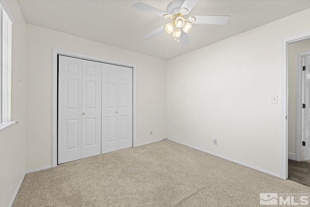unfurnished bedroom featuring a closet, ceiling fan, and carpet flooring