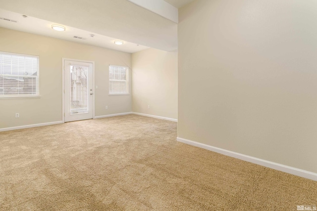 spare room featuring light colored carpet