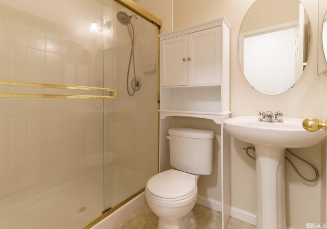 bathroom with sink, a shower with shower door, tile patterned floors, and toilet