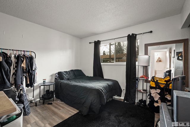 bedroom featuring a textured ceiling and wood finished floors