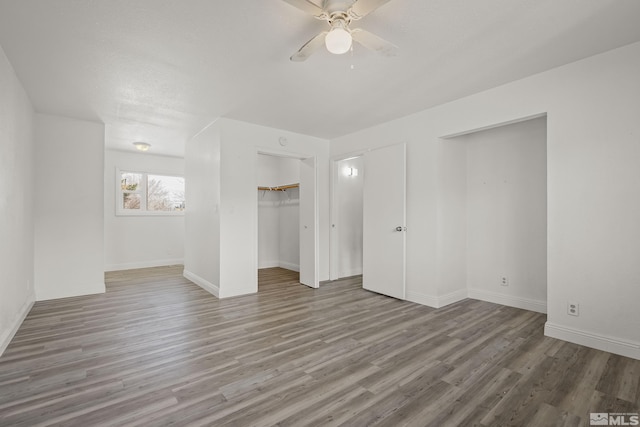 empty room with a ceiling fan, baseboards, and wood finished floors