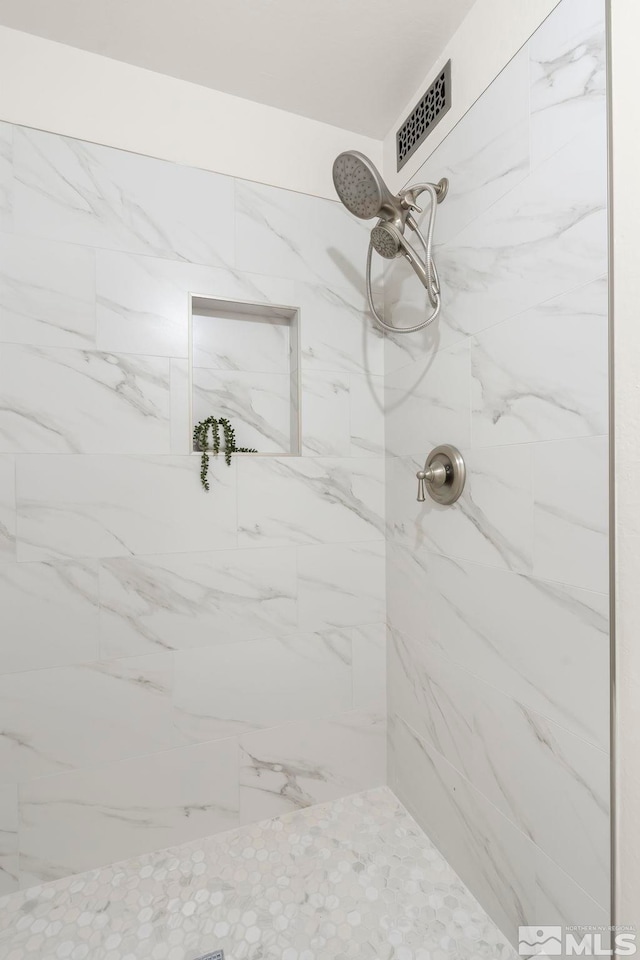 bathroom with tiled shower