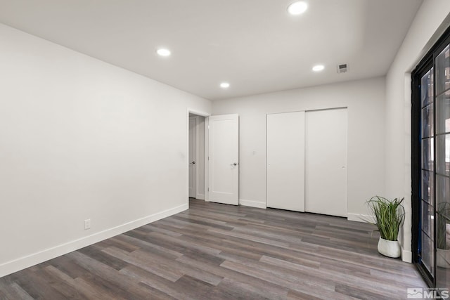 unfurnished bedroom featuring dark hardwood / wood-style flooring and a closet