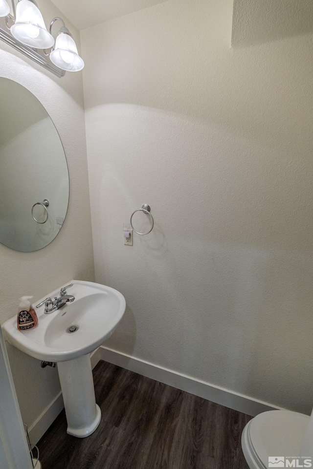 bathroom with hardwood / wood-style floors and toilet