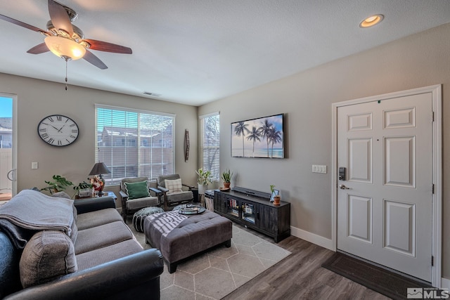 living room with dark wood-type flooring and ceiling fan