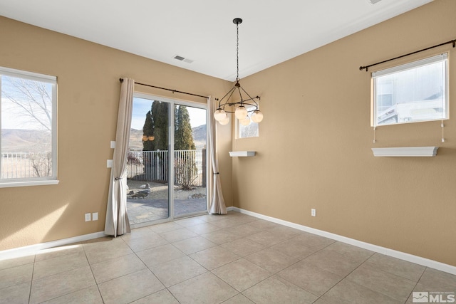 unfurnished dining area with light tile patterned floors and a chandelier