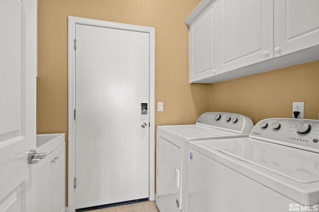 clothes washing area featuring cabinets, washer and clothes dryer, and light tile patterned floors