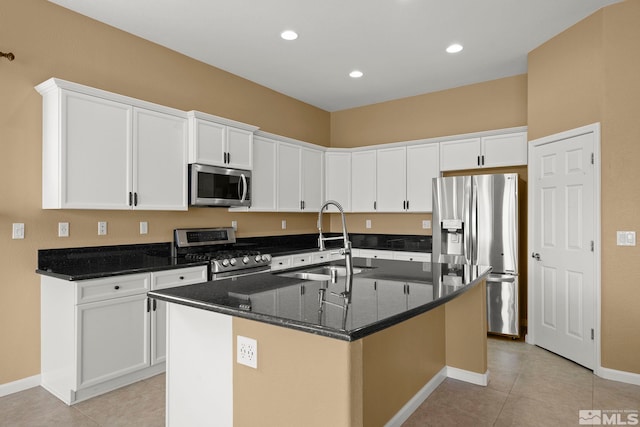 kitchen featuring white cabinets, appliances with stainless steel finishes, sink, and a kitchen island with sink