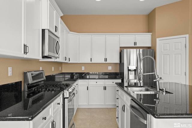 kitchen featuring stainless steel appliances, dark stone counters, and white cabinets