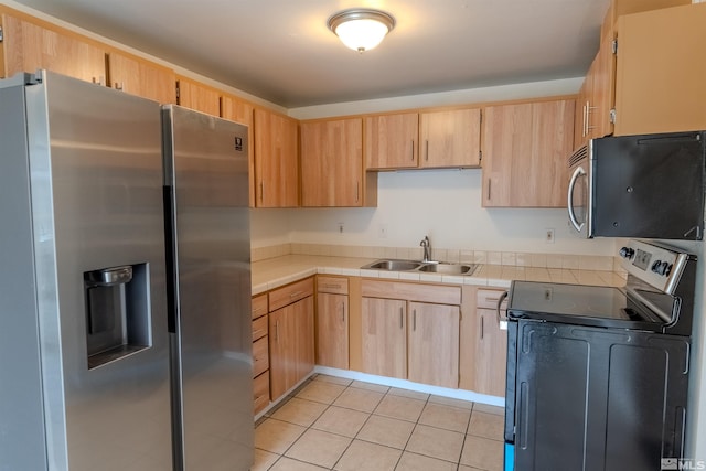 kitchen with light brown cabinetry, sink, stainless steel appliances, and light tile patterned flooring