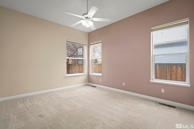 carpeted spare room featuring ceiling fan