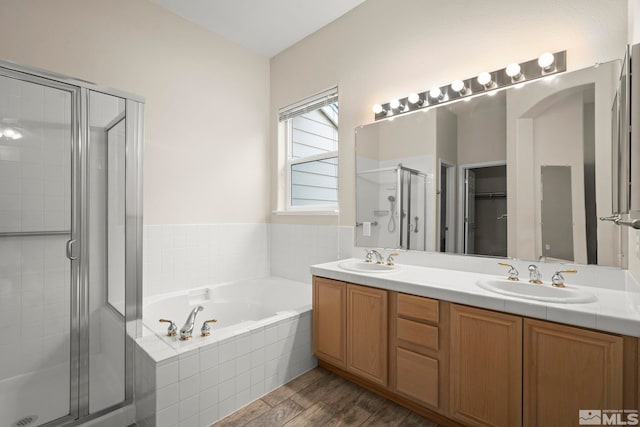 bathroom featuring vanity, wood-type flooring, and separate shower and tub