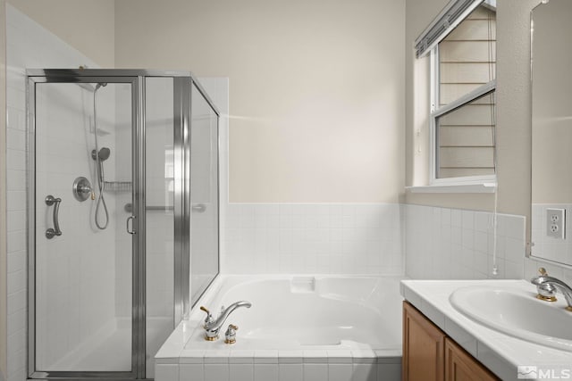 bathroom with vanity and shower with separate bathtub