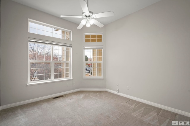 empty room featuring ceiling fan and carpet