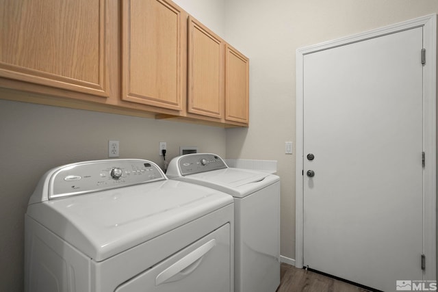 laundry room with cabinets, separate washer and dryer, and light hardwood / wood-style flooring