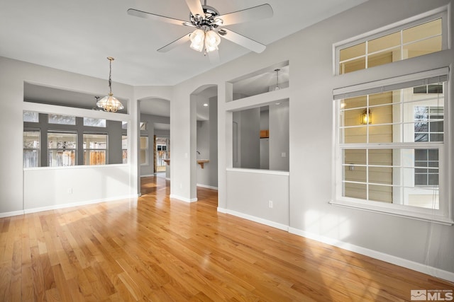 interior space featuring hardwood / wood-style flooring and ceiling fan with notable chandelier