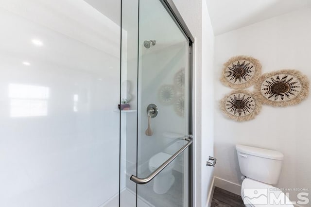 bathroom with a shower with door and toilet