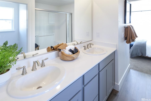 bathroom featuring hardwood / wood-style flooring, vanity, and walk in shower