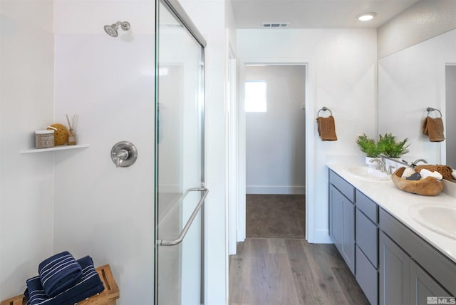 bathroom featuring vanity, a shower with shower door, and hardwood / wood-style floors