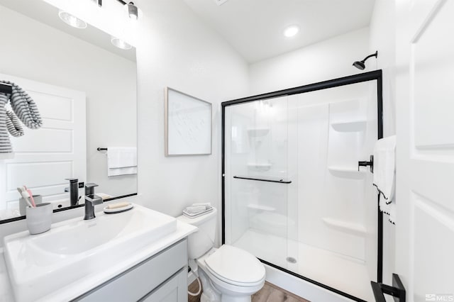 bathroom featuring an enclosed shower, vanity, and toilet