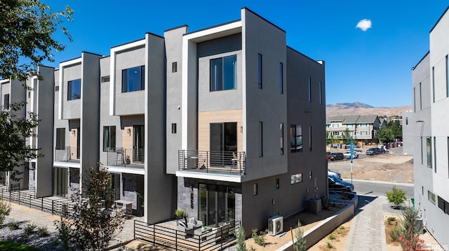 view of building exterior featuring central AC and a mountain view